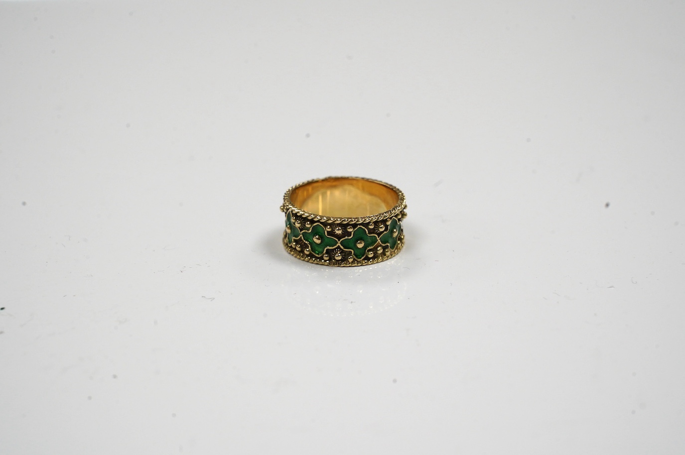 A 14ct gold and green enamel set flower head band, size O/P, gross weight 4.7 grams. Condition - fair